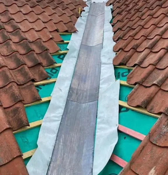 Completed grey tiled roof with repaired chimney